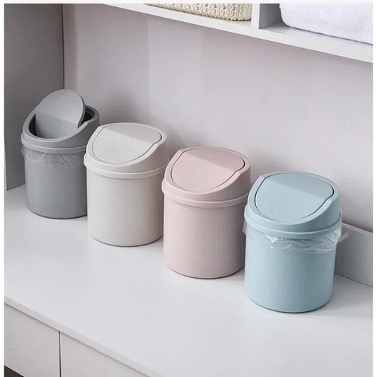 Mini desktop trash can with cover, compact design for home, office, or bedroom use, durable plastic and modern style.  

