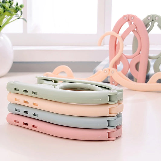 Foldable clothes hanger set for travel and home storage, space-saving plastic design in assorted colors.  
